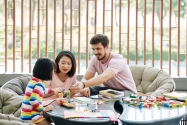 Parents and daughter playing with puzzle toys. Family Lead Safety