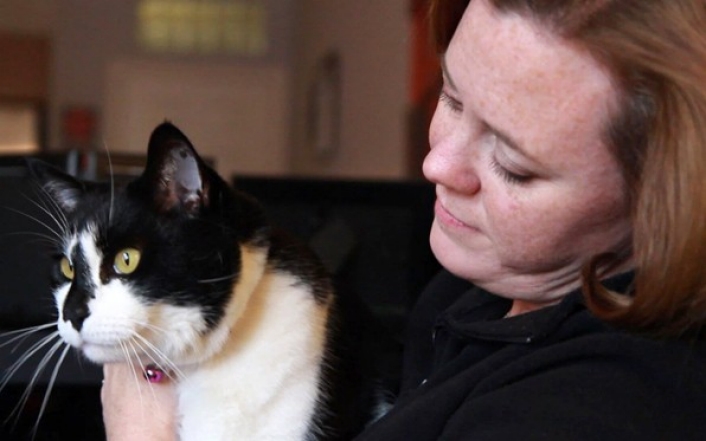 Picture of woman holding black and white cat