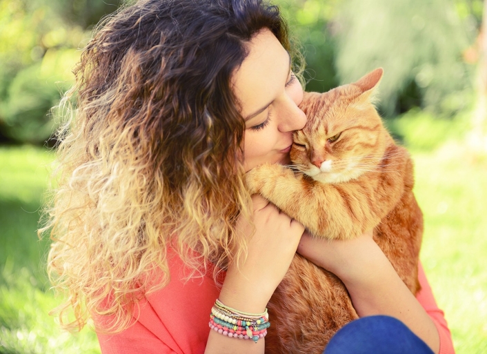 Woman holding orange cat