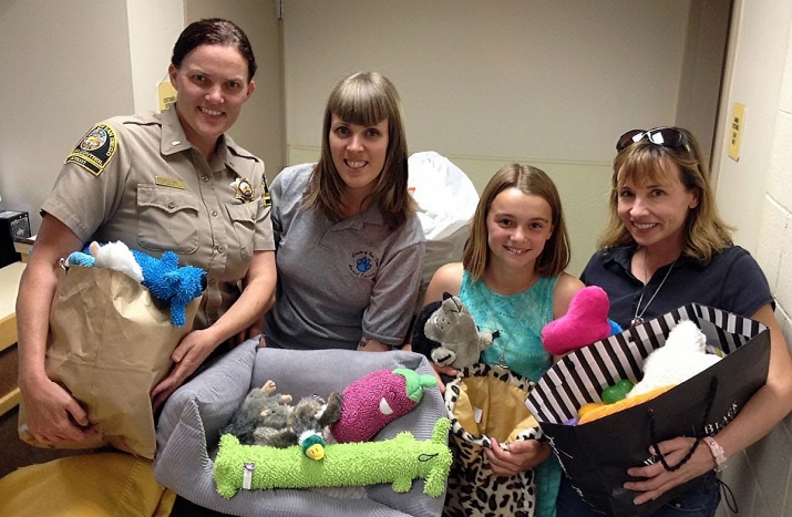 Animal control officer with people donating toys for animals