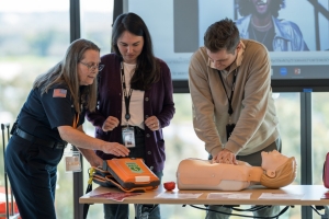 emergency medical technician using an AED on older man who is unconcious