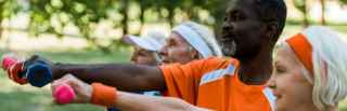 Group of older adults lifting dumbbells outdoors