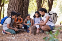 Happy students and teacher examinig tree stump Happy students and teacher examinig tree stump